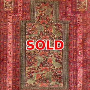 Persian-style decorative rug with red borders and a floral central pattern; marked SOLD.