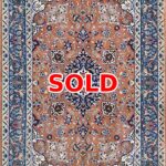 Persian-style rug with an orange field and blue floral border, marked SOLD.