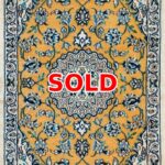 Sold: gold-toned oriental rug with an intricate blue floral pattern and central medallion