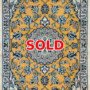 Sold: gold-toned oriental rug with an intricate blue floral pattern and central medallion