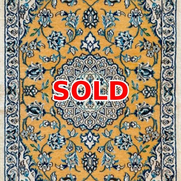 Sold: gold-toned oriental rug with an intricate blue floral pattern and central medallion